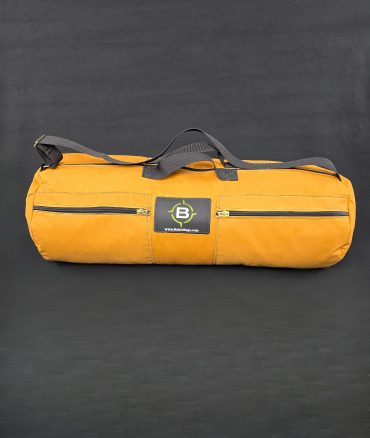 Rolled tan Butler Bedroll with grey handle and black strap on dark background