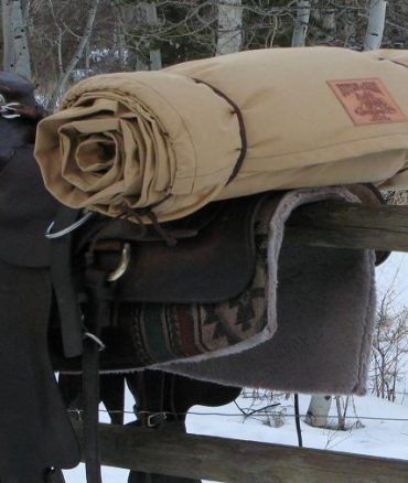 Rolled canvas Horseback Bedroll strapped to a saddle
